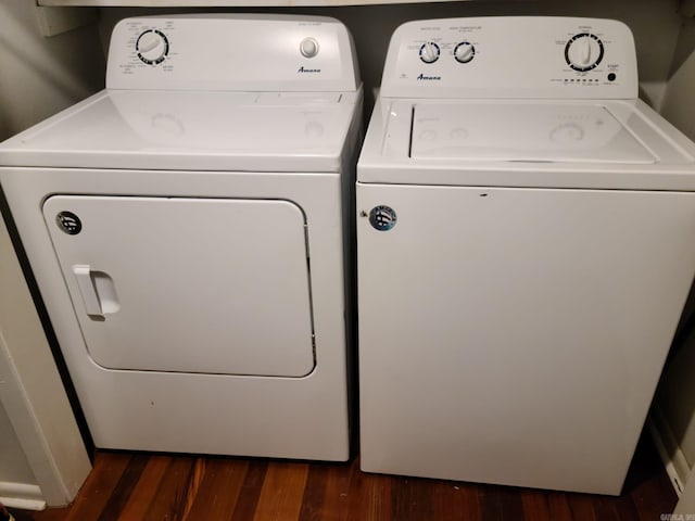 clothes washing area featuring laundry area, dark wood-type flooring, and washer and dryer