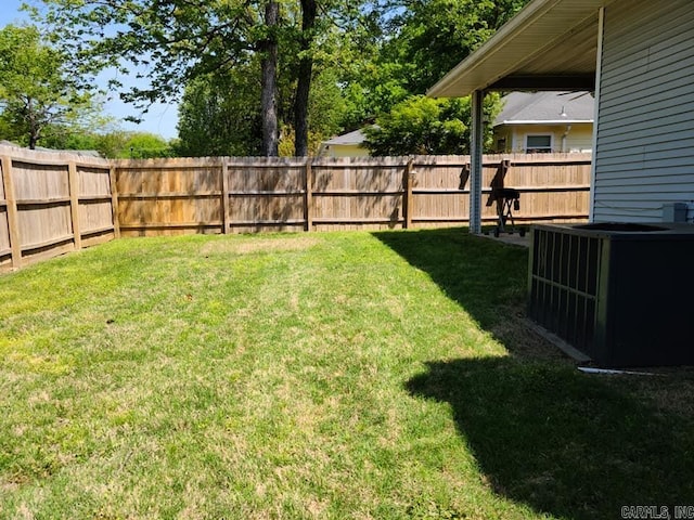 view of yard with central AC unit and a fenced backyard