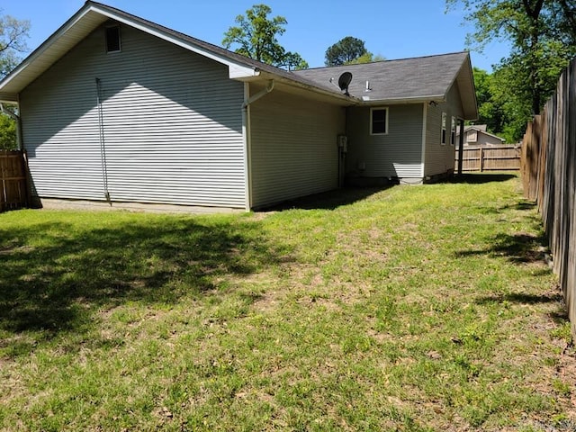 back of property with fence and a lawn