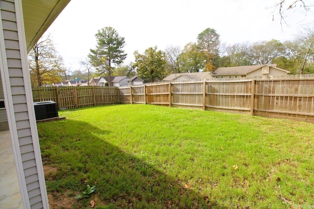 view of yard with a fenced backyard and central AC