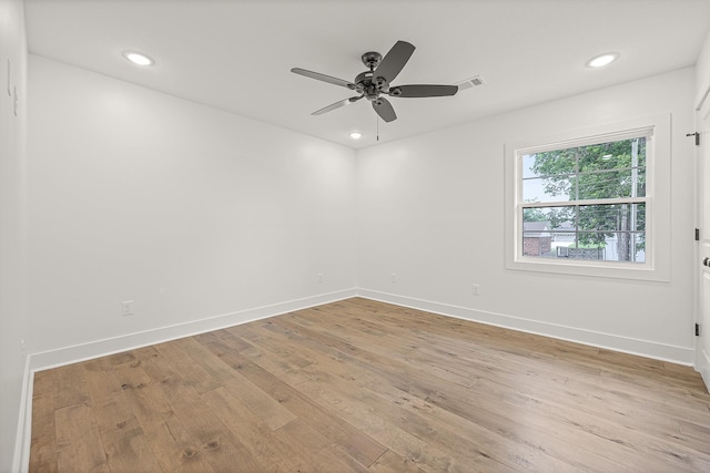 empty room featuring light wood-type flooring, visible vents, baseboards, and recessed lighting