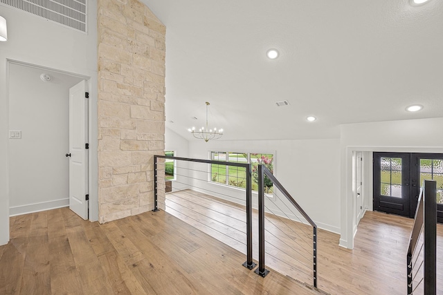 corridor with light wood-type flooring, a healthy amount of sunlight, and visible vents