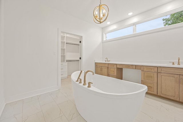 bathroom with baseboards, marble finish floor, a walk in closet, a freestanding bath, and recessed lighting