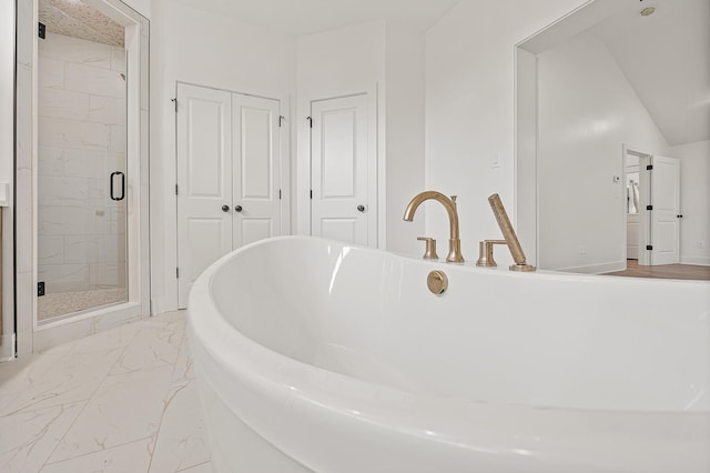 bathroom featuring marble finish floor, a freestanding tub, and a marble finish shower