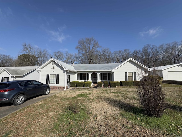 single story home featuring metal roof and a front lawn