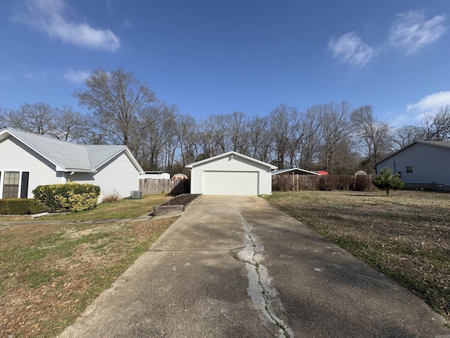 view of front of house featuring a garage, driveway, cooling unit, and a front yard