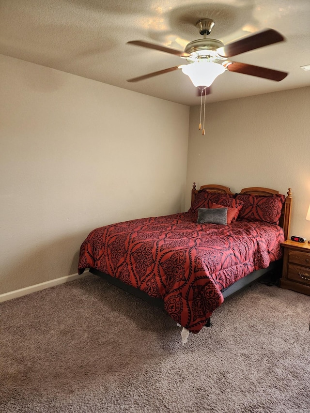 bedroom with a textured ceiling, carpet flooring, a ceiling fan, and baseboards