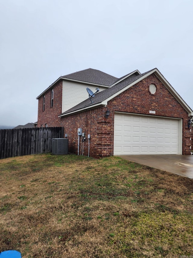 view of home's exterior with central AC unit, a garage, fence, and a yard