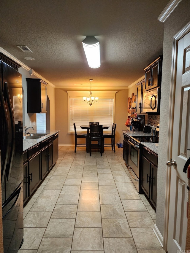 kitchen featuring visible vents, an inviting chandelier, appliances with stainless steel finishes, ornamental molding, and a sink