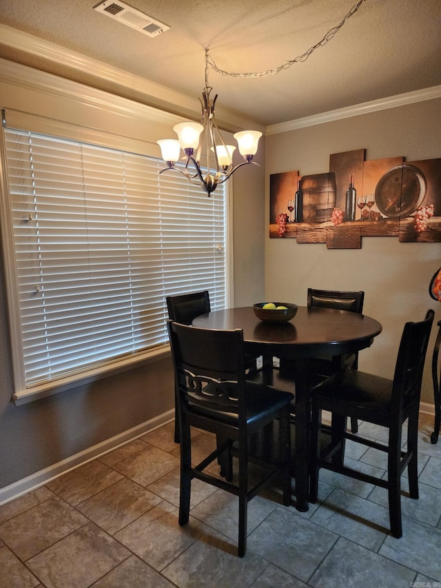 dining room with baseboards, visible vents, a notable chandelier, and ornamental molding