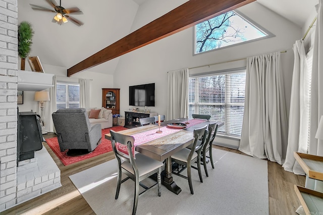 dining room with high vaulted ceiling, beamed ceiling, light wood-style flooring, and a ceiling fan