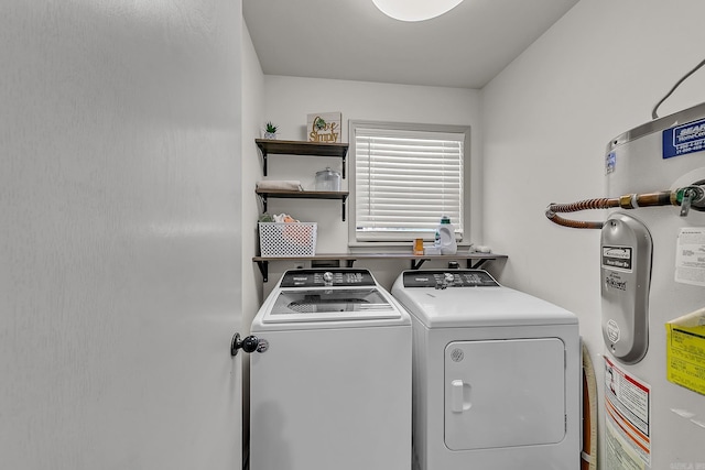 clothes washing area featuring washer and dryer, laundry area, and electric water heater