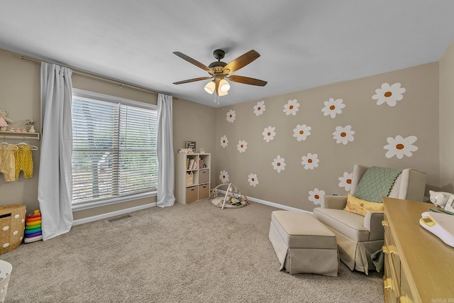 living area featuring light carpet, visible vents, baseboards, and ceiling fan