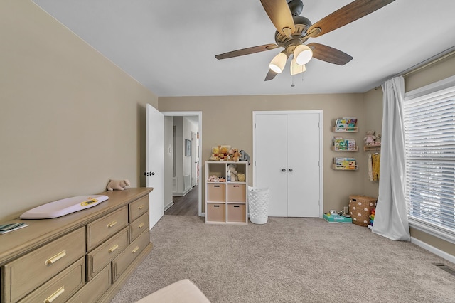 bedroom with a closet, light carpet, ceiling fan, and visible vents