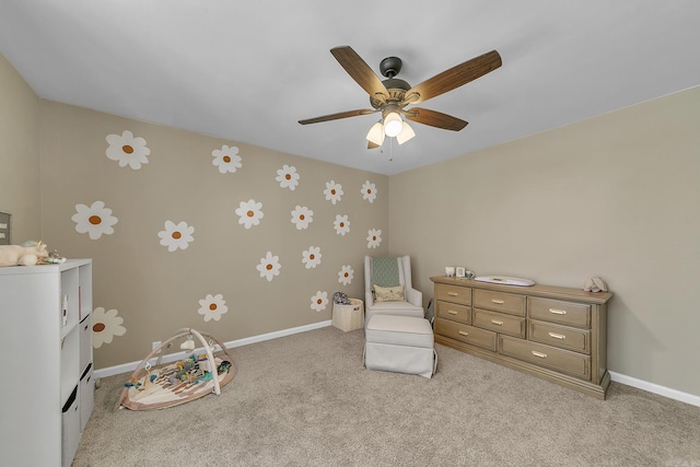 interior space featuring light carpet, a ceiling fan, and baseboards