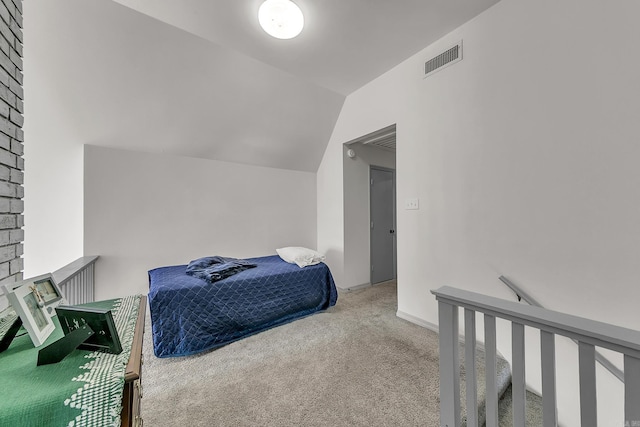 bedroom with carpet floors, visible vents, and vaulted ceiling