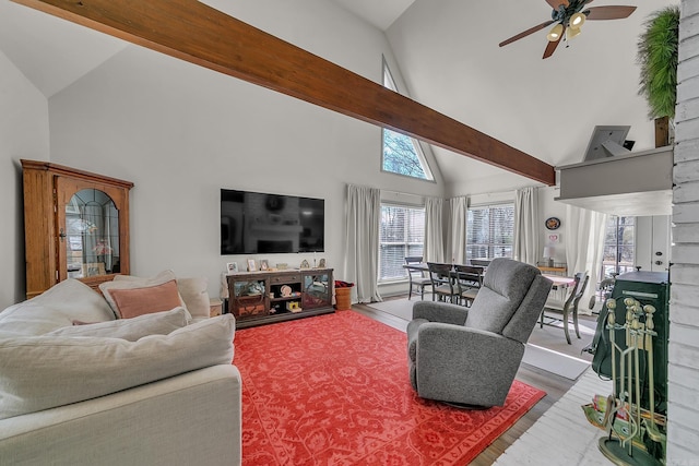 living room with ceiling fan, high vaulted ceiling, beamed ceiling, and wood finished floors