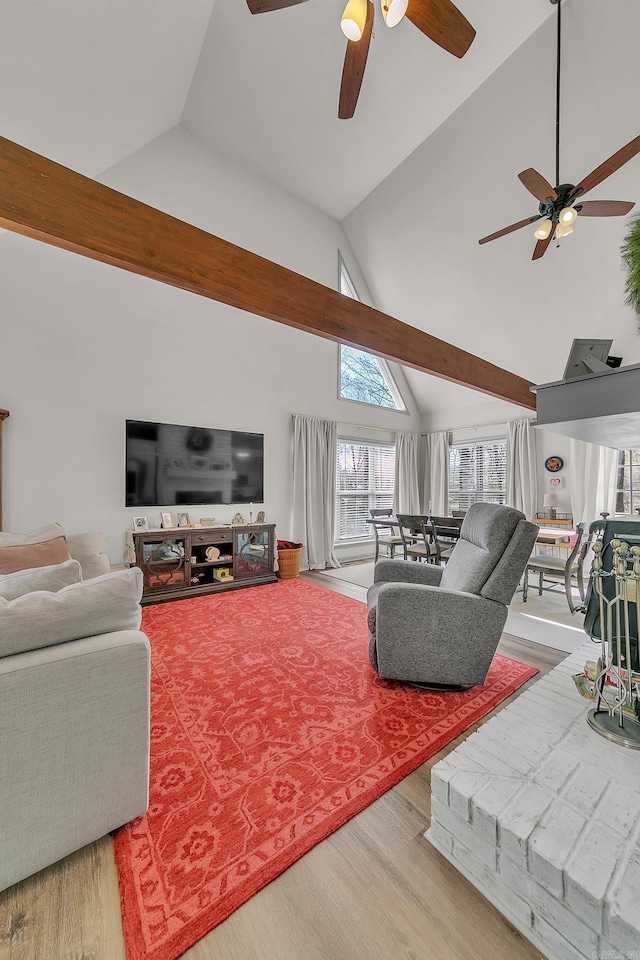 living area with high vaulted ceiling, ceiling fan, and wood finished floors