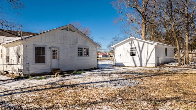 back of property with entry steps and fence