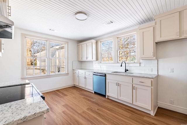 kitchen featuring tasteful backsplash, a sink, stainless steel dishwasher, and light stone countertops