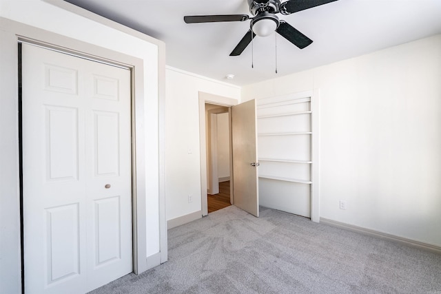 unfurnished bedroom with light carpet, ceiling fan, and baseboards