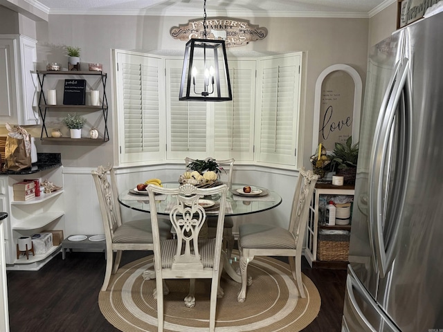 dining space with a chandelier, ornamental molding, and dark wood-style flooring