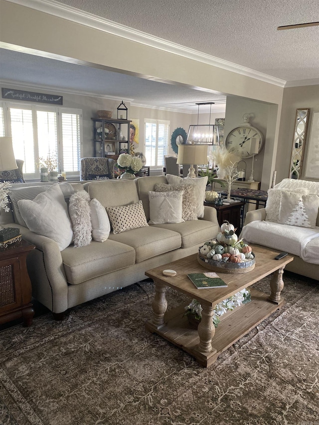 living area featuring ornamental molding, a notable chandelier, and a textured ceiling