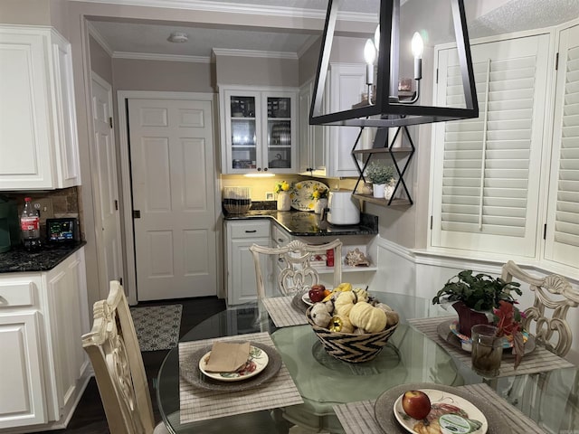 kitchen featuring glass insert cabinets, white cabinets, ornamental molding, and backsplash