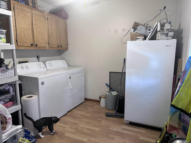 laundry room with cabinet space, baseboards, light wood-style floors, and washing machine and clothes dryer