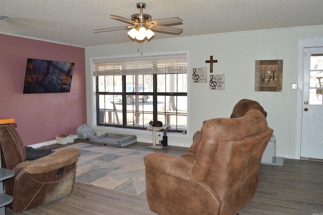 living area with dark wood finished floors, a textured ceiling, and ceiling fan