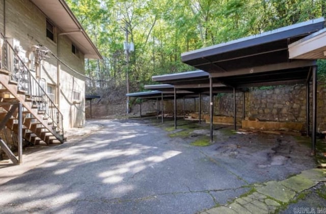 covered parking lot featuring stairway