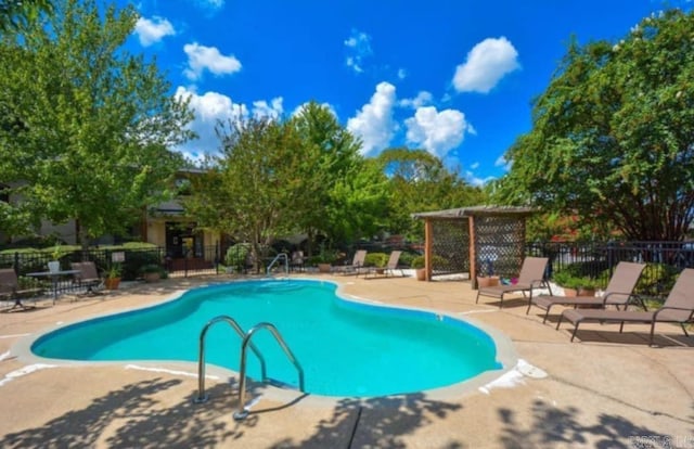 pool featuring fence and a patio