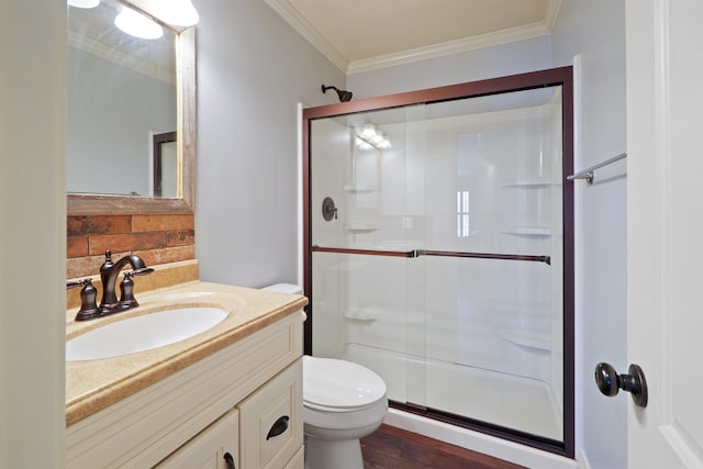 full bath with toilet, wood finished floors, vanity, a shower stall, and crown molding