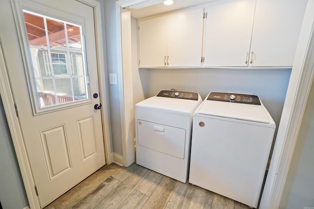 laundry room featuring cabinet space, light wood finished floors, and separate washer and dryer