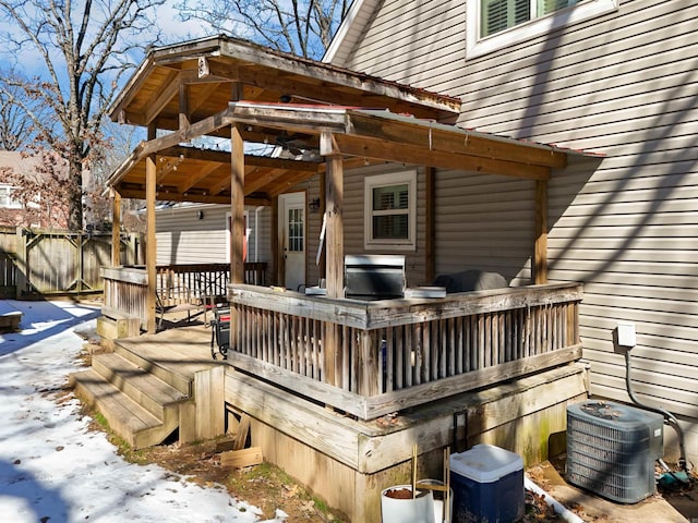 snow covered deck with fence and cooling unit