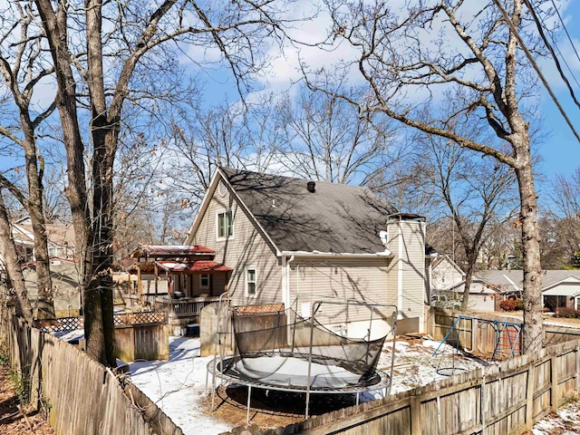 exterior space with a trampoline and a fenced backyard