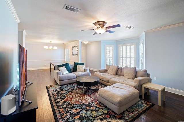 living area with a textured ceiling, wood finished floors, visible vents, and crown molding