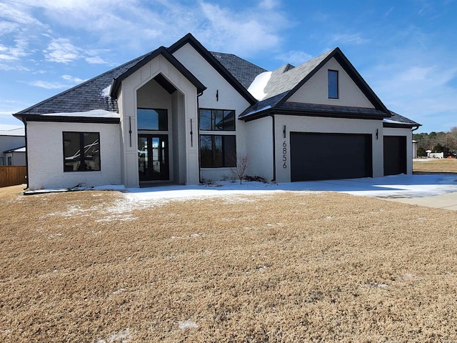 view of front facade with an attached garage, concrete driveway, brick siding, and a front yard