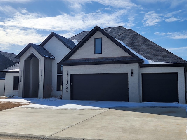 view of front of home featuring concrete driveway, brick siding, and an attached garage