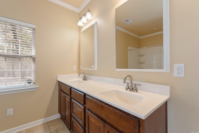 bathroom featuring plenty of natural light, crown molding, and a sink