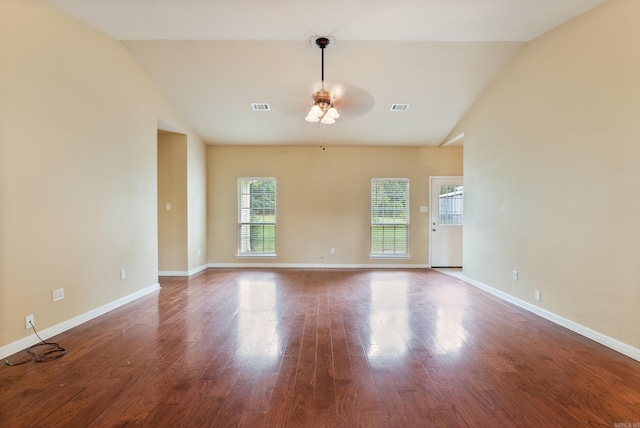 spare room featuring lofted ceiling, baseboards, visible vents, and wood finished floors