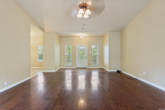 empty room featuring a ceiling fan, baseboards, and wood finished floors