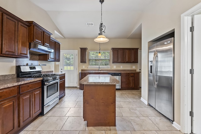 kitchen featuring a kitchen island, appliances with stainless steel finishes, under cabinet range hood, pendant lighting, and a sink