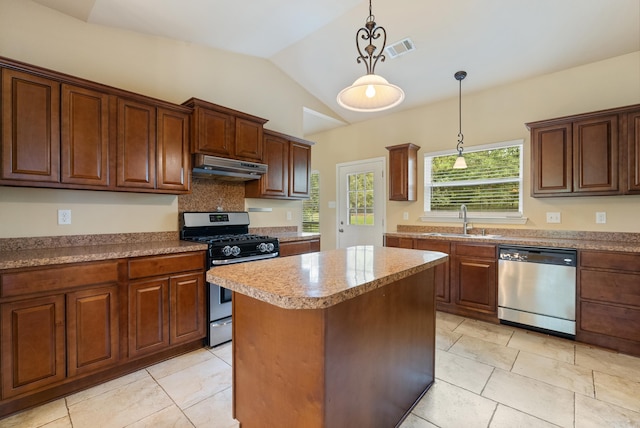 kitchen featuring under cabinet range hood, stainless steel appliances, a sink, visible vents, and a center island