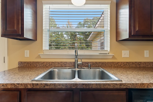 kitchen featuring dark brown cabinets, a sink, and light countertops