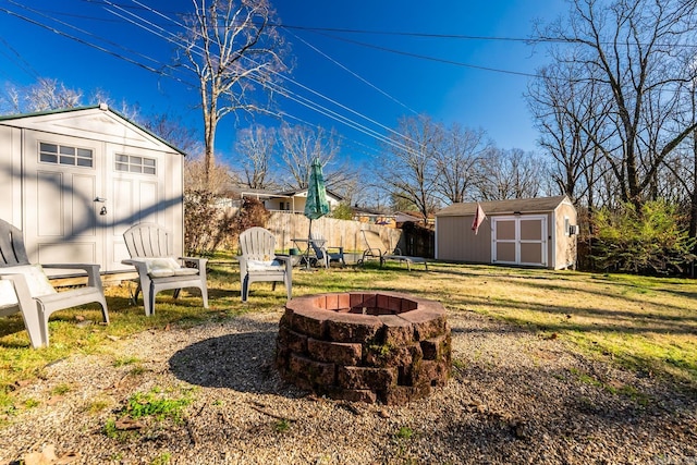 view of yard with an outdoor fire pit, an outdoor structure, fence, and a shed