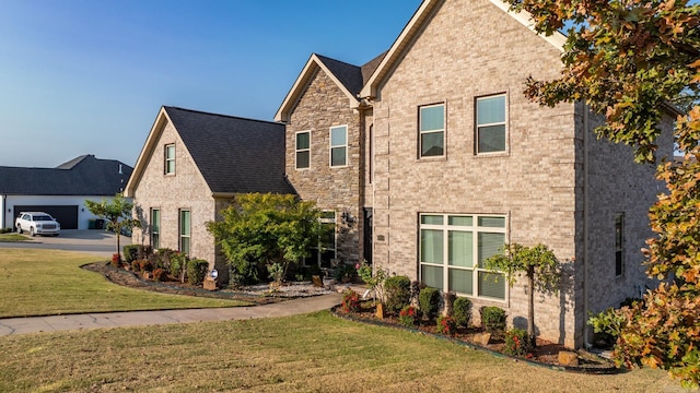 view of front of home featuring brick siding, a front lawn, and roof with shingles