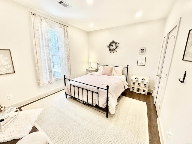 bedroom with dark wood-style floors, recessed lighting, visible vents, and baseboards