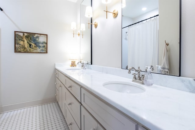 bathroom with double vanity, a sink, and baseboards