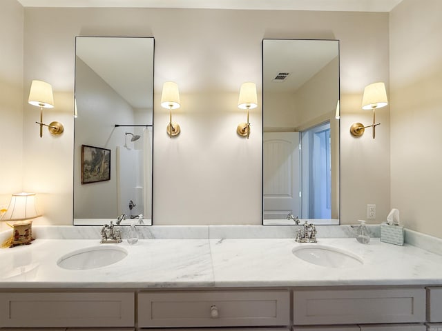 bathroom with visible vents, a sink, and double vanity